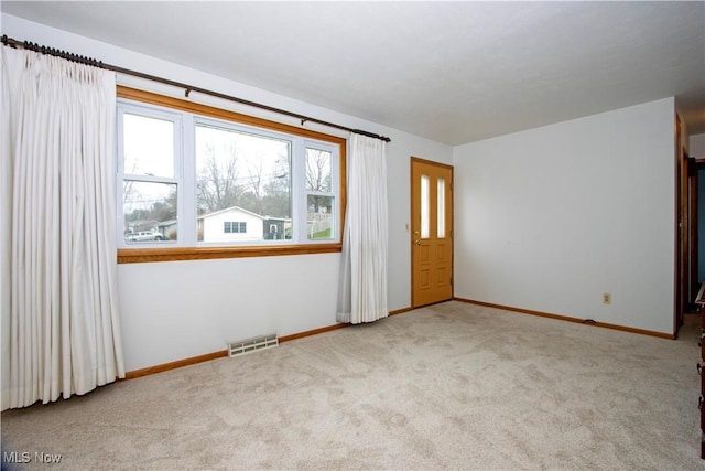 spare room with baseboards, visible vents, and carpet