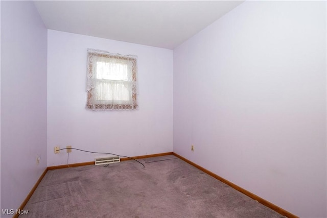carpeted empty room featuring visible vents and baseboards