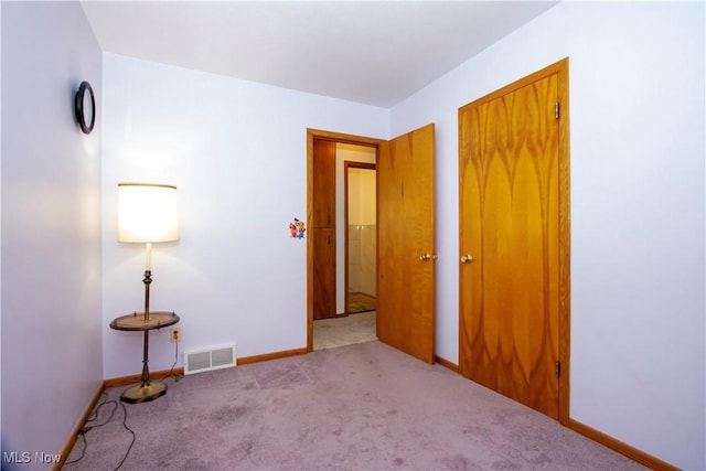 unfurnished bedroom featuring visible vents, carpet flooring, and baseboards