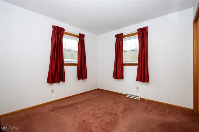 spare room featuring baseboards, visible vents, carpet flooring, and plenty of natural light