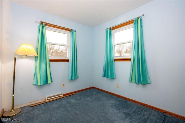 carpeted spare room with baseboards and visible vents