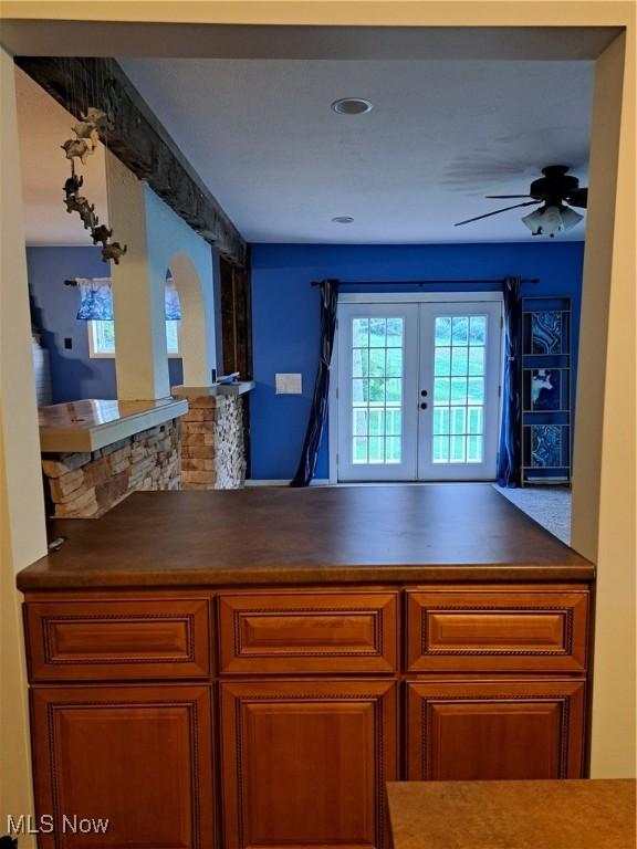 49197 John Tomcho Rd, Cumberland, OH 43732 - kitchen featuring french doors, ceiling fan, brown cabinetry, and dark countertops