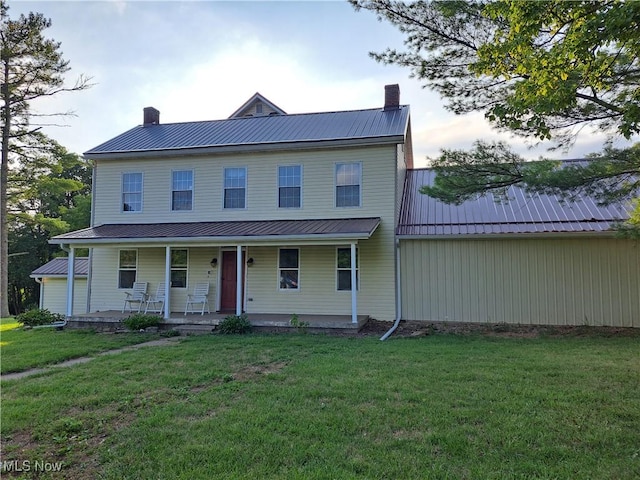 49197 John Tomcho Rd, Cumberland, OH 43732 - view of front of home with a chimney, metal roof, a front yard, and covered porch