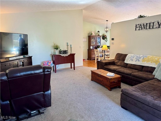 carpeted living area with vaulted ceiling