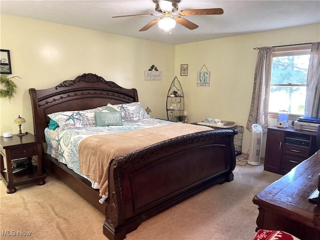 bedroom with light colored carpet and a ceiling fan