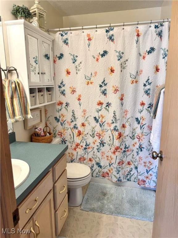 full bath with toilet, tile patterned floors, and vanity