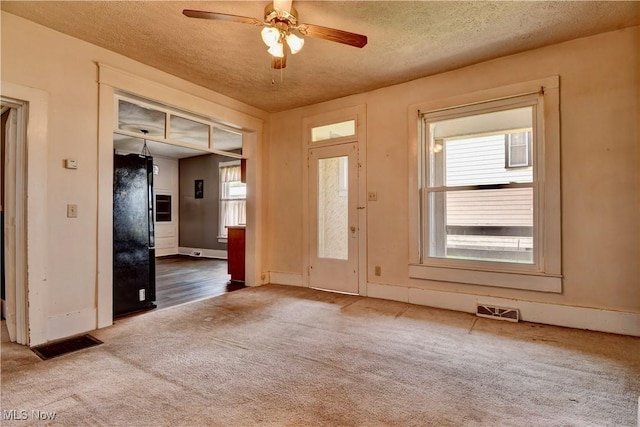 610 N 2nd St, Dennison, OH 44621 - carpeted empty room with a ceiling fan, a textured ceiling, visible vents, and baseboards