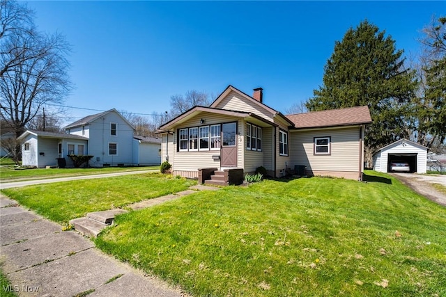 bungalow-style house featuring driveway, an outdoor structure, a chimney, and a front yard