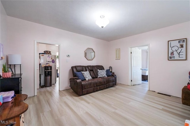 living room with visible vents and light wood-style floors