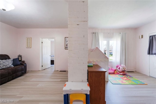 game room with light wood-type flooring and decorative columns