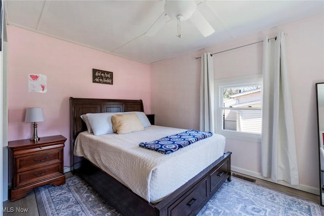 bedroom featuring visible vents, ceiling fan, and wood finished floors