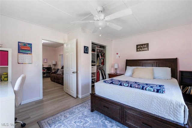 bedroom featuring light wood-type flooring, a ceiling fan, baseboards, and a closet