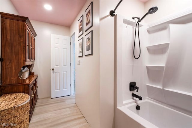 bathroom featuring wood finished floors, recessed lighting, and  shower combination