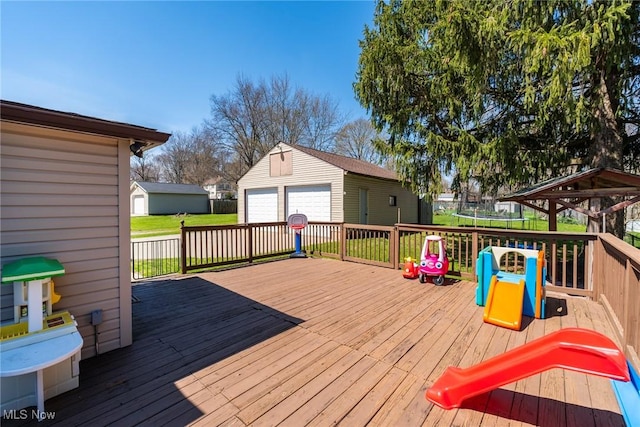 deck with a detached garage, a trampoline, and an outdoor structure