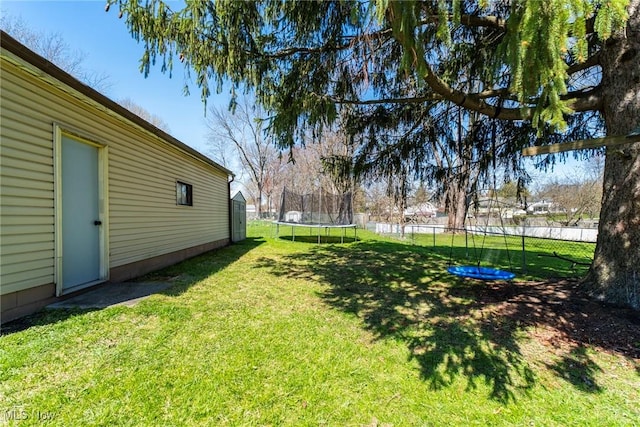 view of yard with a trampoline and fence