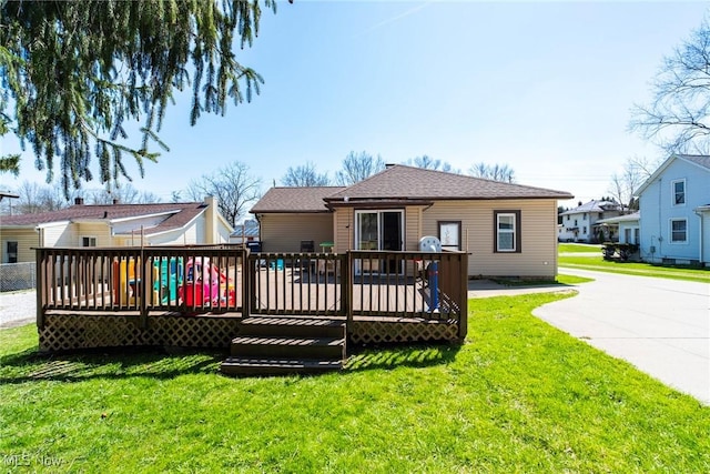 rear view of house with a wooden deck and a yard