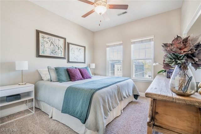 bedroom with visible vents, ceiling fan, light colored carpet, and baseboards