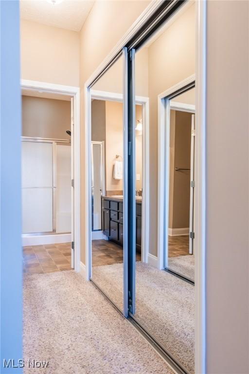 corridor featuring carpet floors and baseboards