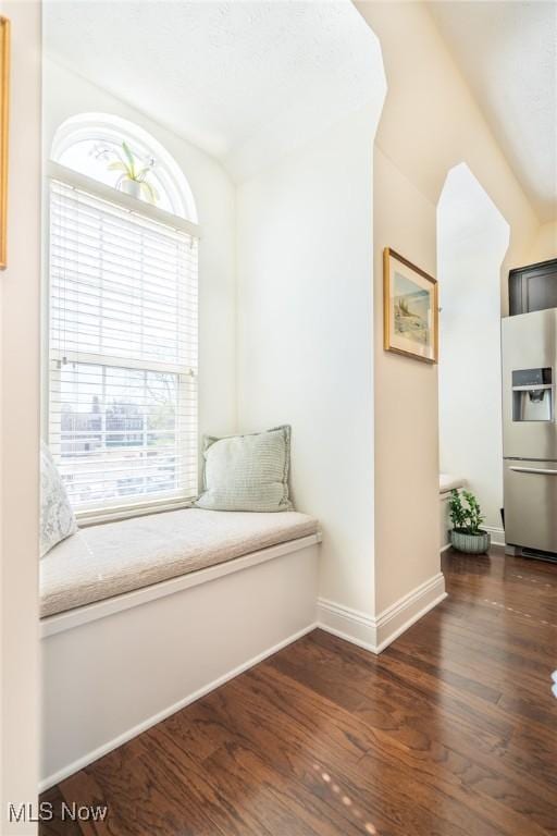 sitting room featuring baseboards, dark wood-style floors, and lofted ceiling