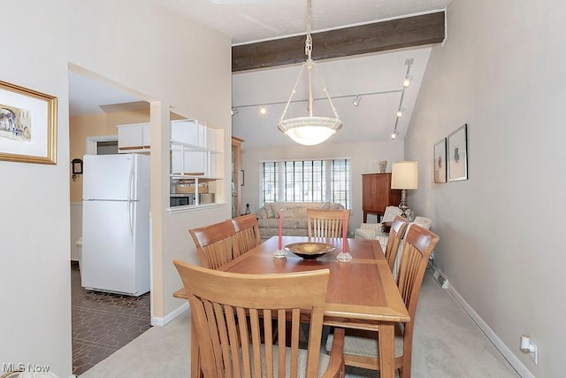 dining space with light colored carpet, vaulted ceiling with beams, and baseboards