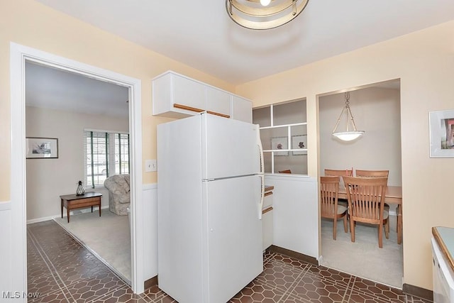 kitchen featuring white cabinets and freestanding refrigerator