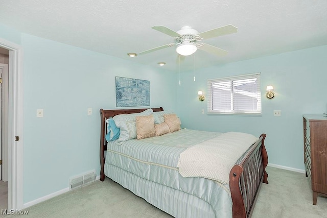 bedroom with baseboards, visible vents, light carpet, and ceiling fan