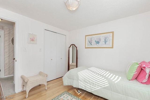 bedroom with light wood-style floors and a closet
