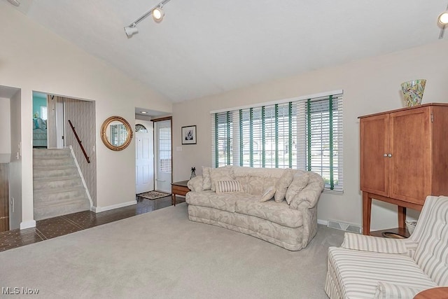 living room featuring baseboards, visible vents, stairway, and lofted ceiling