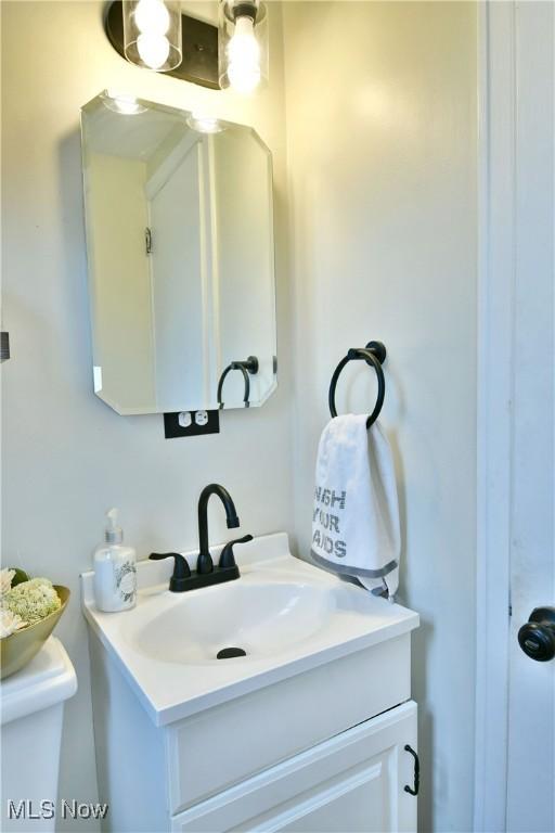 half bathroom featuring toilet and vanity
