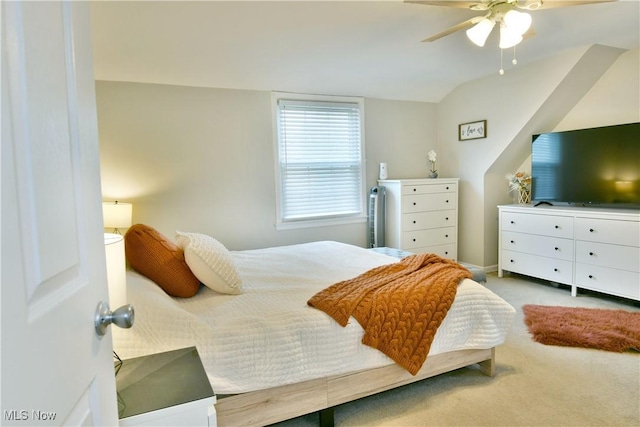 carpeted bedroom with ceiling fan and vaulted ceiling