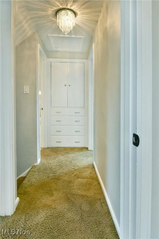 hallway with light colored carpet and baseboards