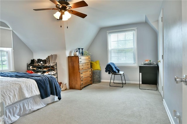 bedroom with carpet, ceiling fan, vaulted ceiling, and multiple windows