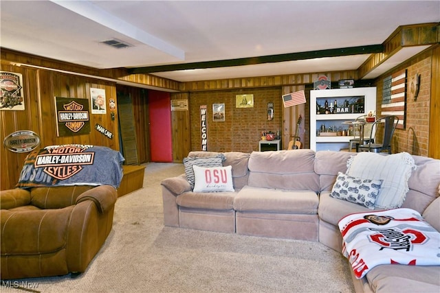 living area featuring carpet flooring, beam ceiling, wood walls, and visible vents
