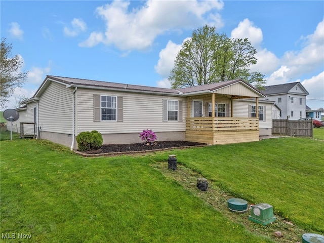 back of property featuring a lawn, fence, and metal roof