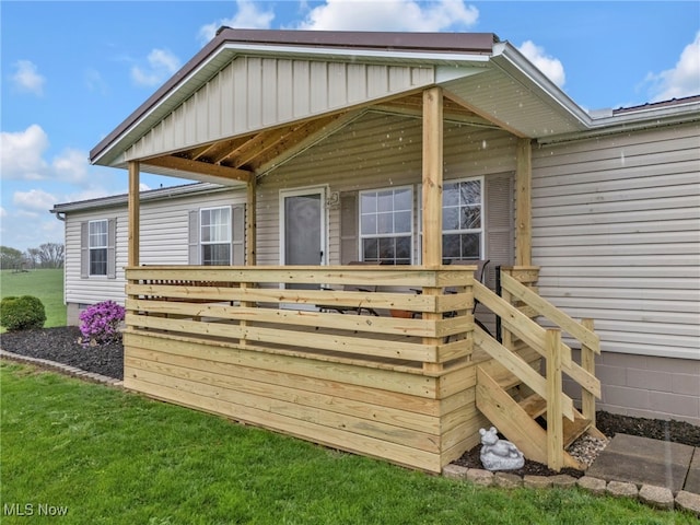 back of house with a deck and a yard