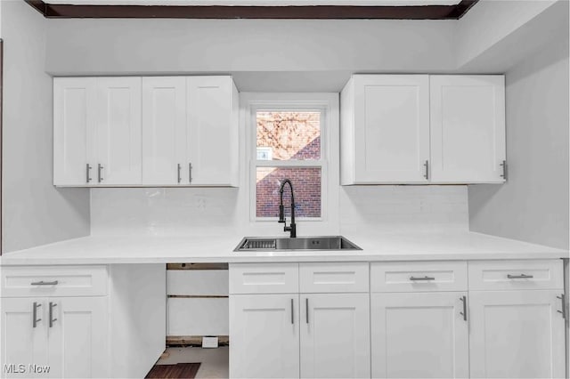 135 W Bagley Rd, Berea, OH 44017 - kitchen with a sink, white cabinetry, decorative backsplash, and light countertops