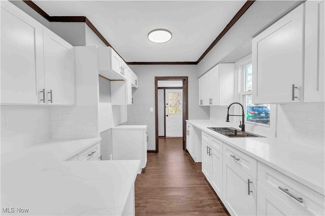 135 W Bagley Rd, Berea, OH 44017 - kitchen with dark wood finished floors, a sink, white cabinets, and tasteful backsplash