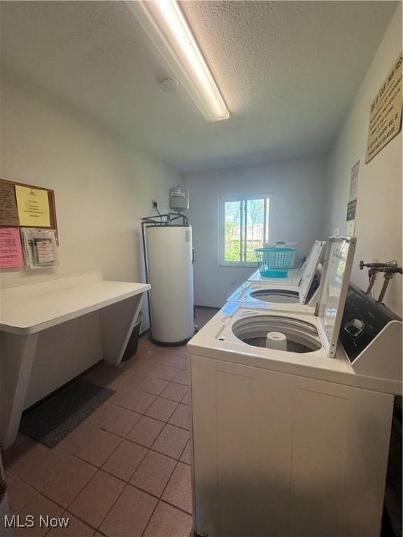 laundry area with water heater, separate washer and dryer, tile patterned flooring, and a textured ceiling