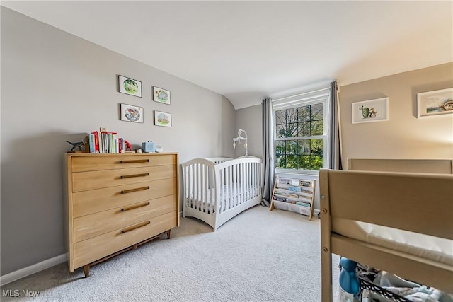 bedroom with a crib and light carpet