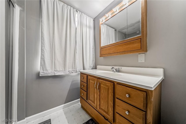 bathroom with baseboards, tile patterned floors, and vanity