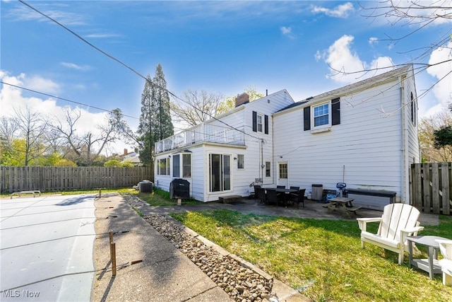 back of house with a chimney, a fenced backyard, a yard, a patio area, and cooling unit