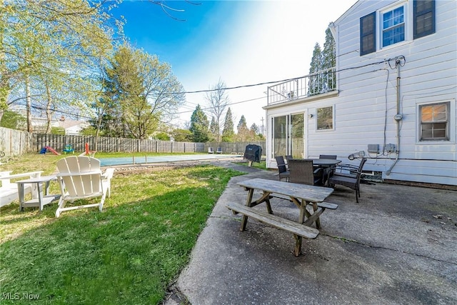 view of yard with outdoor dining space, a balcony, a patio, and a fenced backyard