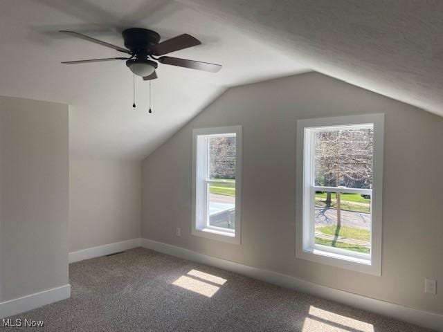 additional living space featuring lofted ceiling, carpet, a ceiling fan, and baseboards