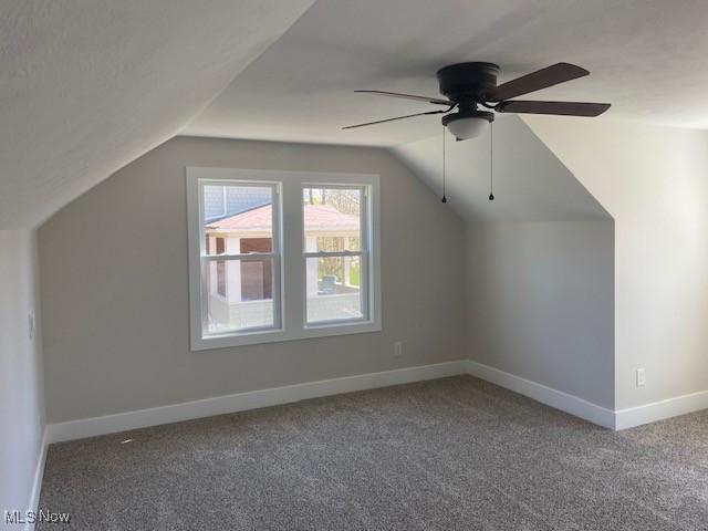 additional living space with lofted ceiling, a ceiling fan, carpet flooring, and baseboards