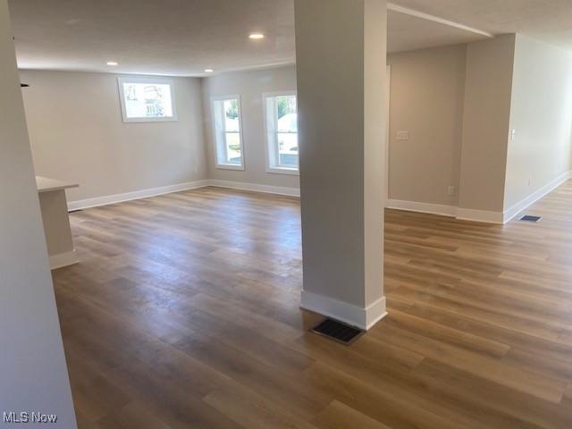 basement with baseboards, recessed lighting, wood finished floors, and visible vents