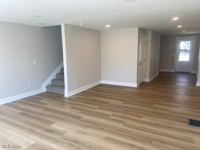 basement with visible vents, baseboards, recessed lighting, wood finished floors, and stairs