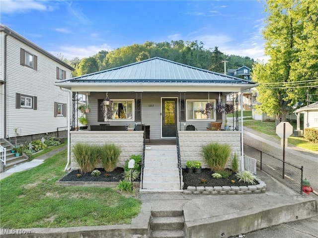 bungalow-style home with a porch, metal roof, and stairs
