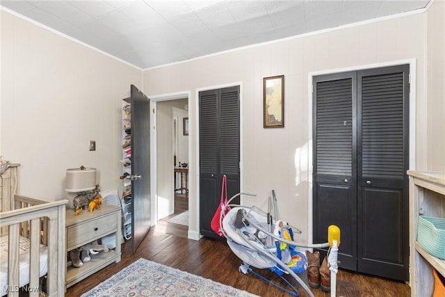 bedroom with ornamental molding and dark wood-style flooring
