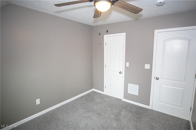 unfurnished bedroom with visible vents, ceiling fan, carpet, and baseboards