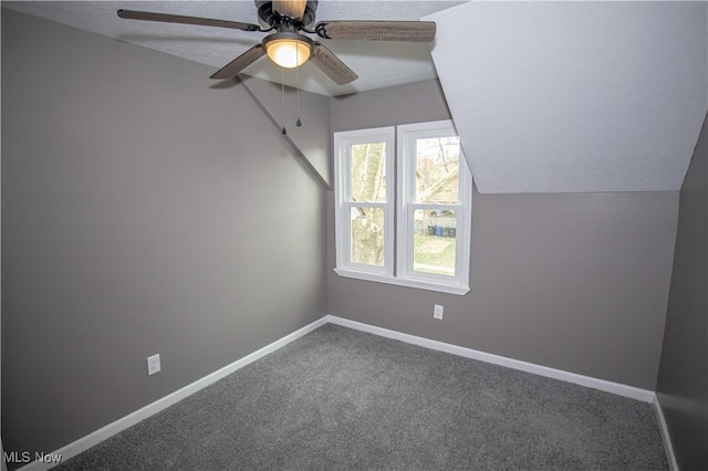 bonus room with carpet floors, vaulted ceiling, baseboards, a ceiling fan, and a textured ceiling
